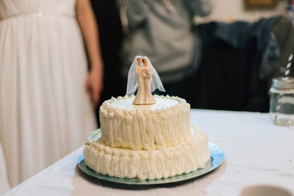 Close-up of a white wedding cake with a bride and groom topper, perfect for wedding celebrations.